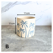 Load image into Gallery viewer, Arbor planters with palm tree design on a marble surface, featuring the Leaferie brand.
