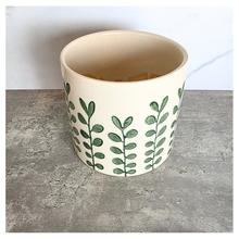 Load image into Gallery viewer, Marvelle Ceramic planter with green leaf pattern on a gray surface, branded 'LEAFAERIE'.
