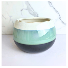 Load image into Gallery viewer, A round ceramic planter with a two-tone glaze design, featuring a pale mint green band across the middle and a dark charcoal gray base, set against a white marble-patterned background.

