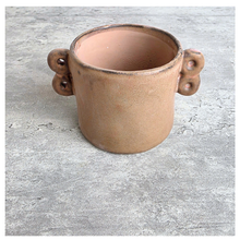 Load image into Gallery viewer, Dovra Brown ceramic planter with handles on a light gray surface, branded 'LEAFERIE'.
