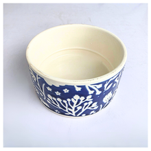 Load image into Gallery viewer, A round ceramic bowl with a cream-colored interior and a blue-and-white floral patterned exterior, shown on a light gray background.
