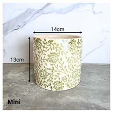 Load image into Gallery viewer, Selora Decorative planter with green floral pattern on a gray surface, featuring the brand 'LEAFERIE'.
