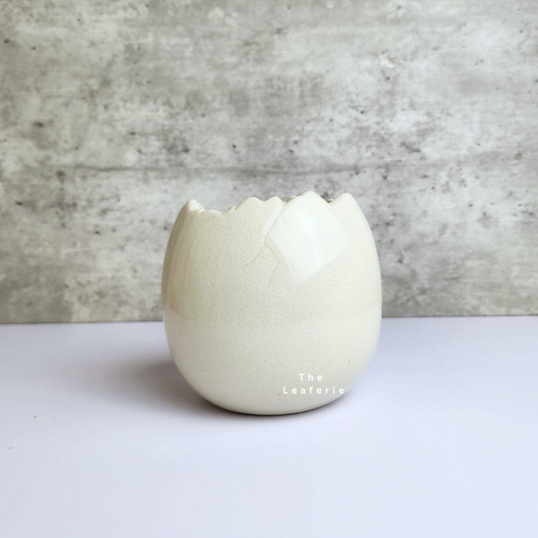 The Leaferie Maja Egg flowerpot. cream white ceramic pot. front view of designs A