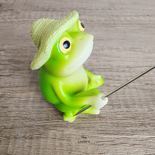 Load image into Gallery viewer, Green frog figurine with a straw hat on a wooden surface
