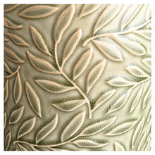 Load image into Gallery viewer, Nyra Green ceramic planter with leaf pattern on a gray surface, featuring the Leaferie brand.
