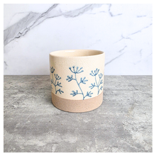 Load image into Gallery viewer, Evie floralCylindrical fabric basket with blue floral patterns on a light background, featuring the brand 'LEAFERIE'.
