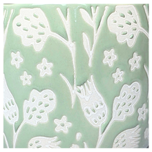 Load image into Gallery viewer, Coralie Green ceramic planter with white floral patterns on a gray background, featuring the brand &#39;LEAFERIE&#39;.
