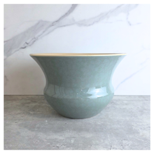 Load image into Gallery viewer, Soren Green ceramic vase with gold rim on a light gray surface, branded 'LEAFERIE'.
