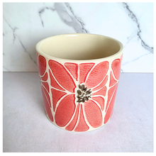 Load image into Gallery viewer, A ceramic planter pot with a coral pink and cream floral pattern, featuring a small metallic gold flower accent in the center, set against a white marble background.
