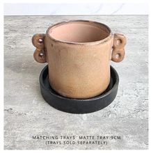 Load image into Gallery viewer, Dovra Brown ceramic planter with handles on a light gray surface, branded 'LEAFERIE'.
