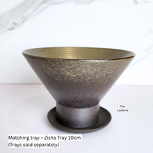 Load image into Gallery viewer, Bronze-colored ceramic planterl with matching tray on a white background, branded &#39;The Leaferie&#39;.
