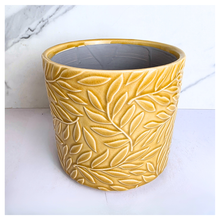 Load image into Gallery viewer, Marigold Yellow ceramic pot with leaf pattern on a marble background, featuring the Leaferie brand.
