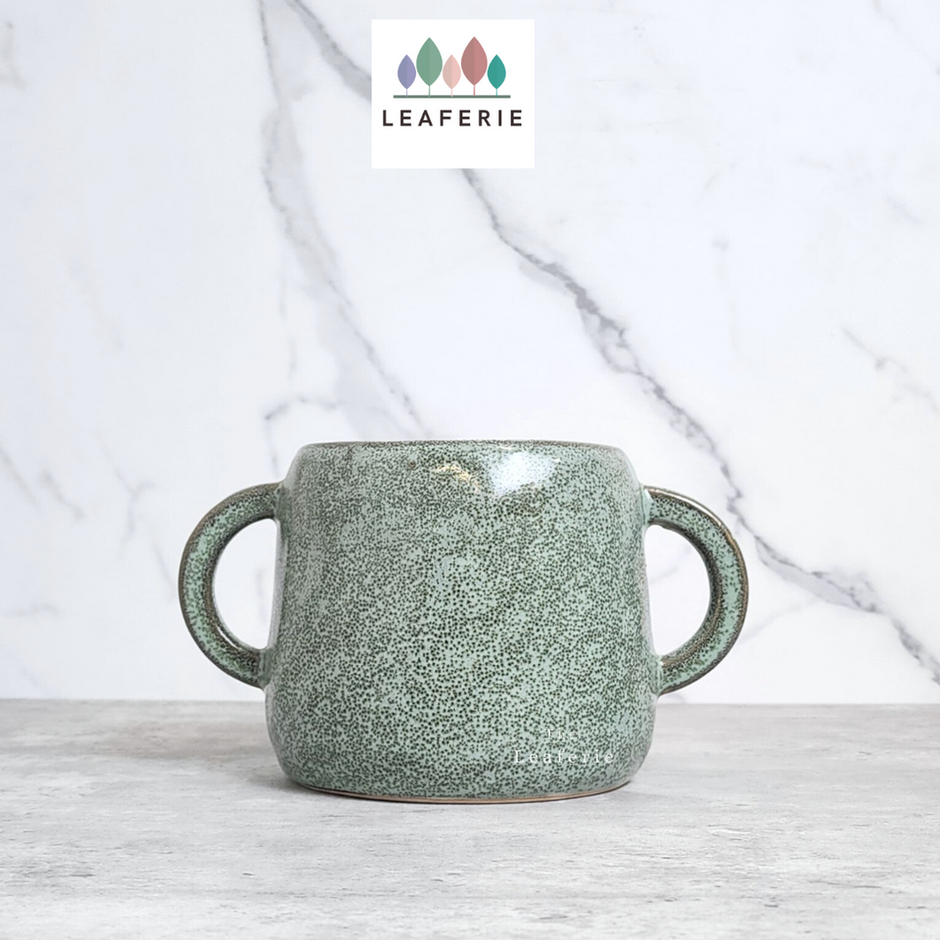 The Leaferie Naoki green plant pot with 2 handles. ceramic material. front view 